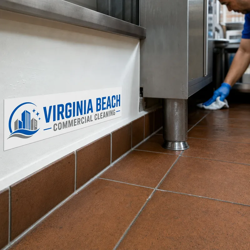 Clean commercial kitchen floor line behind equipment with degreased baseboards and corners and no visible buildup